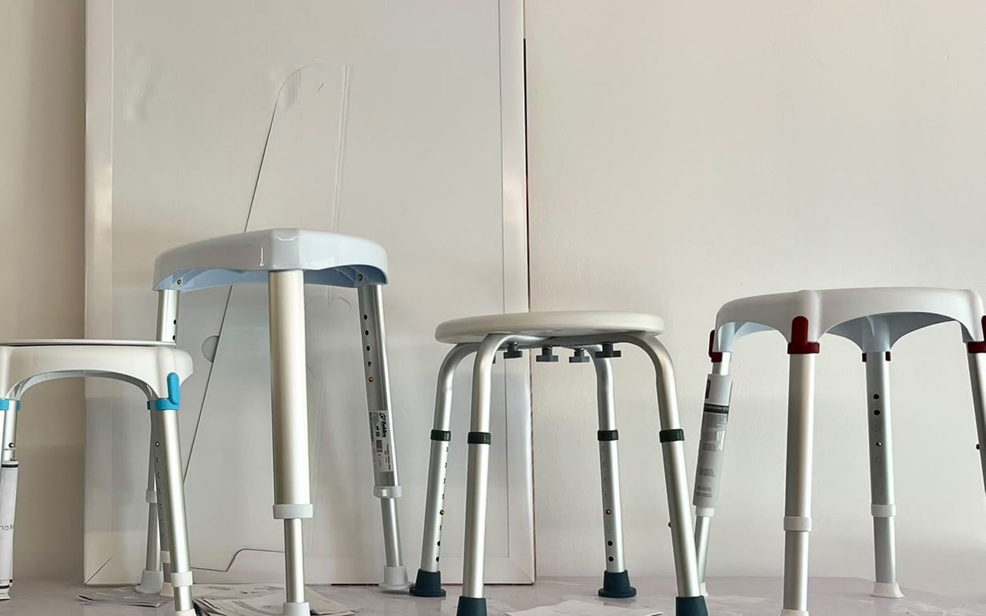 Sgabelli da doccia esposti da Sanitaria Cinel: seduta triangolare, tonda e tonda maxi su gambe in alluminio regolabili